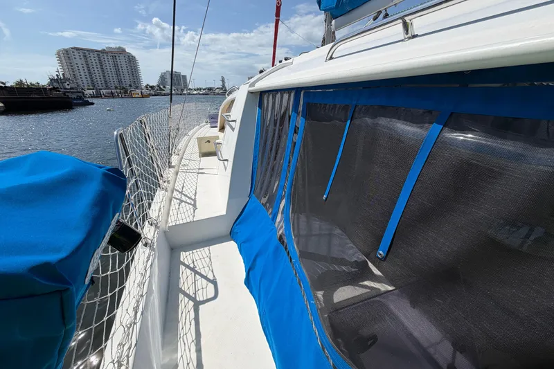 Slide: The Image of Leopard 40 catamaran, 2017 model, docked with blue covers and netting, sunny marina view. - 50