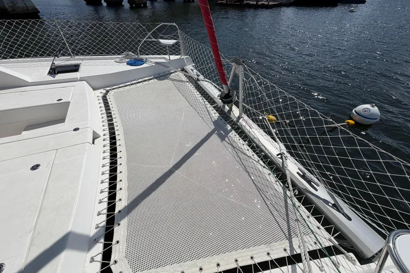 Slide: The Image of Catamaran deck of 2017 Leopard 40, featuring netting and mooring lines on calm water. - 58