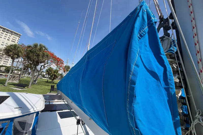 Slide: The Image of Blue sail cover on a 2017 Leopard 40 catamaran, docked near palm trees. - 59