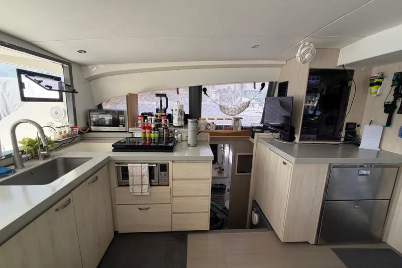 Slide: The Image of Modern kitchen interior of a 2017 Leopard 40 catamaran, featuring sleek cabinetry and appliances. - 85