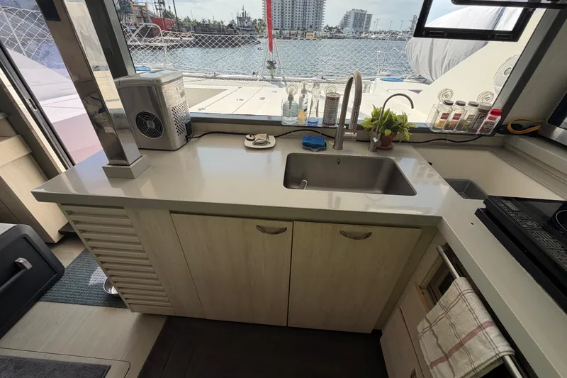 Slide: The Image of Modern kitchen on a 2017 Leopard 40 catamaran with sink, countertop, and marina view. - 89