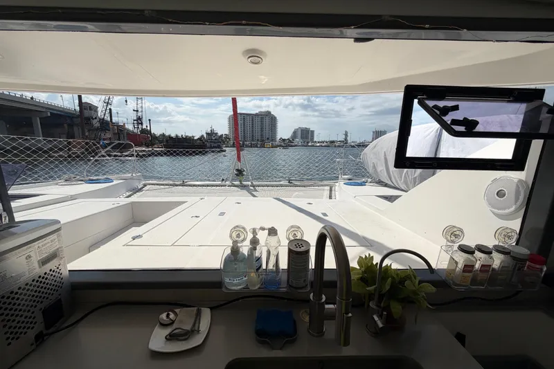 Slide: The Image of Interior view from a 2017 Leopard 40 catamaran, overlooking a marina through a kitchen window. - 92