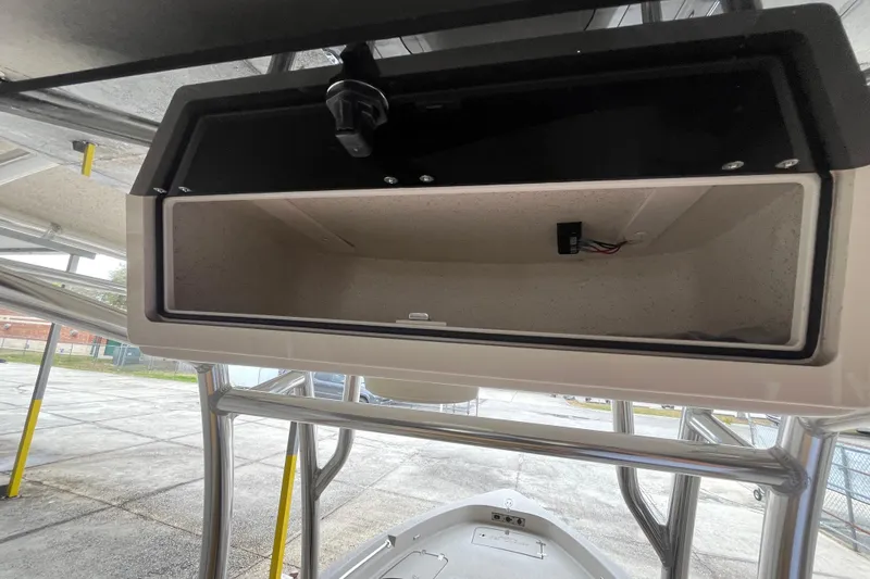 Slide: The Image of 2024 Sea Chaser 21 LX boat storage compartment, open and empty, with visible wiring. - 16