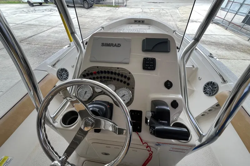 Slide: The Image of 2024 Sea Chaser 21 LX boat dashboard with steering wheel and navigation controls. - 17