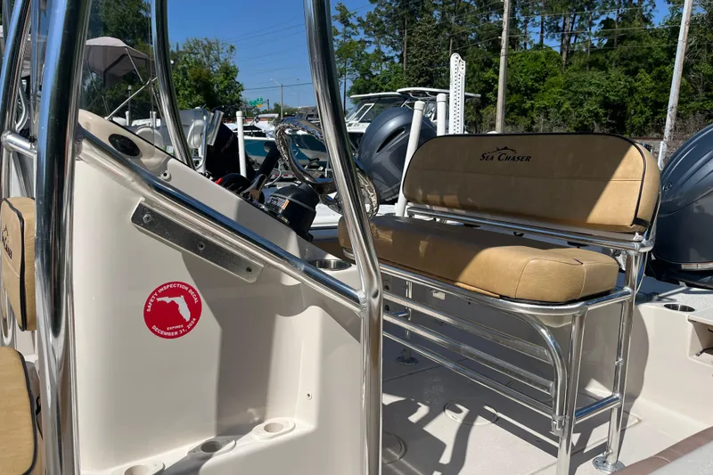 Slide: The Image of 2024 Sea Chaser 21 LX boat interior with tan seating and safety inspection decal. - 22