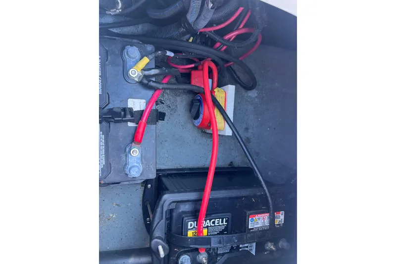 Slide: The Image of Battery compartment of 2024 Sea Chaser 21 LX with cables and connections visible. - 24