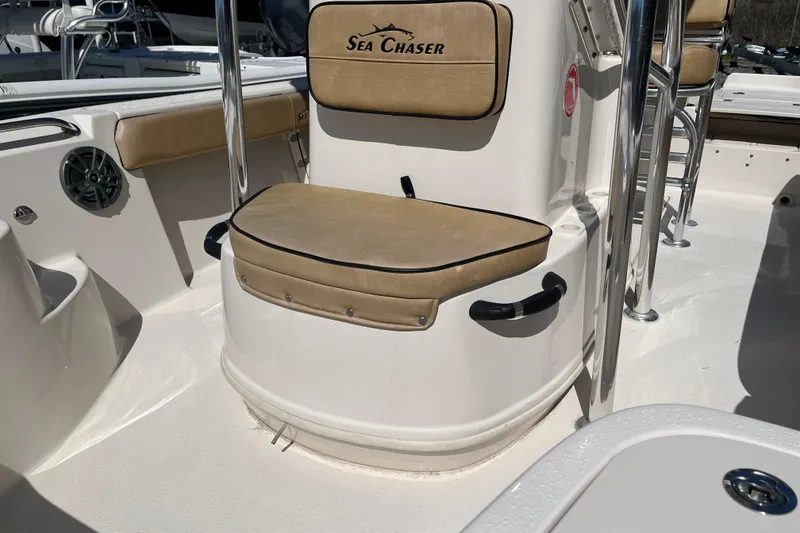 Slide: The Image of 2024 Sea Chaser 21 LX boat interior with cushioned seating and stainless steel fixtures. - 7