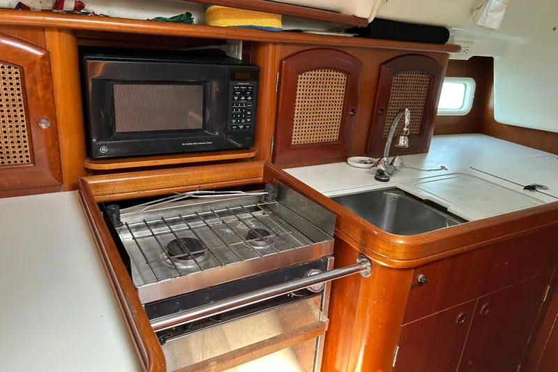 Slide: The Image of Galley kitchen in 2000 Beneteau Oceanis Clipper 411 with stove, microwave, and sink. - 18