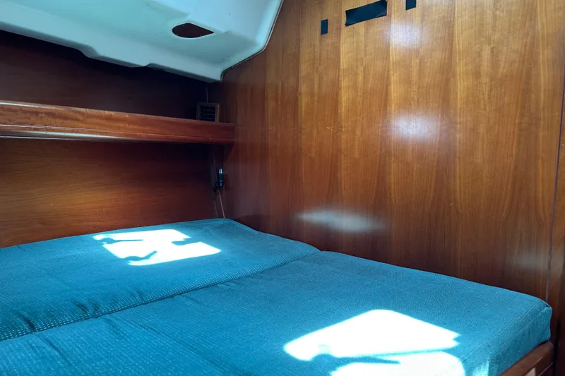 Slide: The Image of Cozy cabin interior of 2000 Beneteau Oceanis Clipper 411 with wooden paneling and blue bedding. - 35