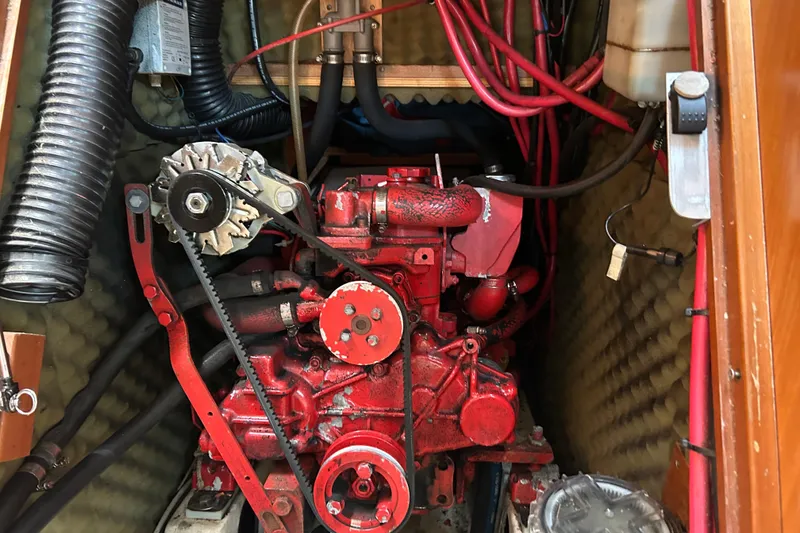 Slide: The Image of Engine compartment of a 2000 Beneteau Oceanis Clipper 411 sailboat, featuring red mechanical components. - 32