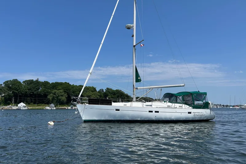 Slide: The Image of 2000 Beneteau Oceanis Clipper 411 sailboat anchored on calm water under clear blue sky. - 1