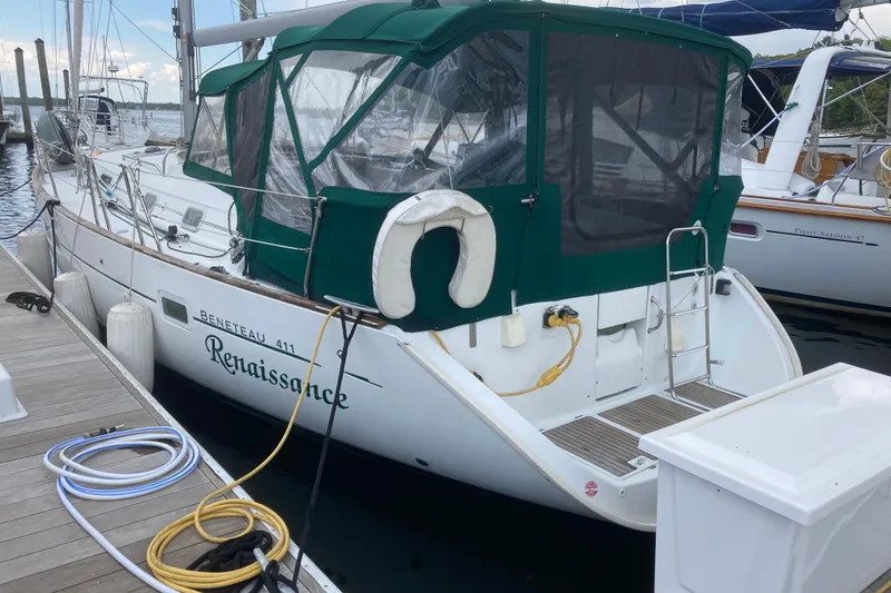 Slide: The Image of Beneteau Oceanis Clipper 411 sailboat docked, featuring green canopy and white hull, year 2000. - 4