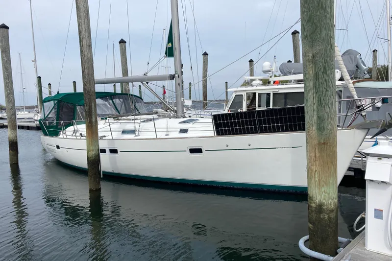 Slide: The Image of 2000 Beneteau Oceanis Clipper 411 sailboat docked at marina with green canopy. - 6