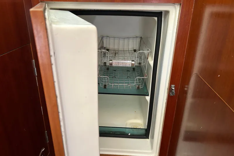 Slide: The Image of Open refrigerator inside 2000 Beneteau Oceanis Clipper 411 yacht, featuring wire shelves. - 19