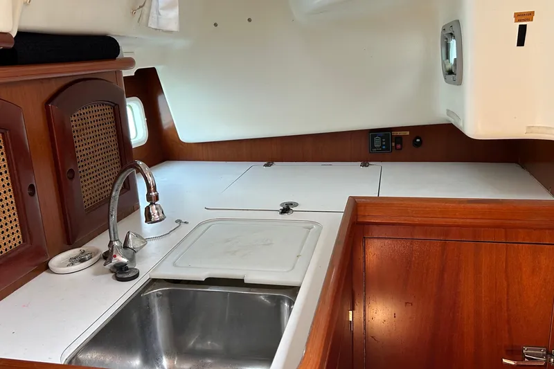 Slide: The Image of Interior view of 2000 Beneteau Oceanis Clipper 411 yacht kitchen with sink and wooden cabinetry. - 17