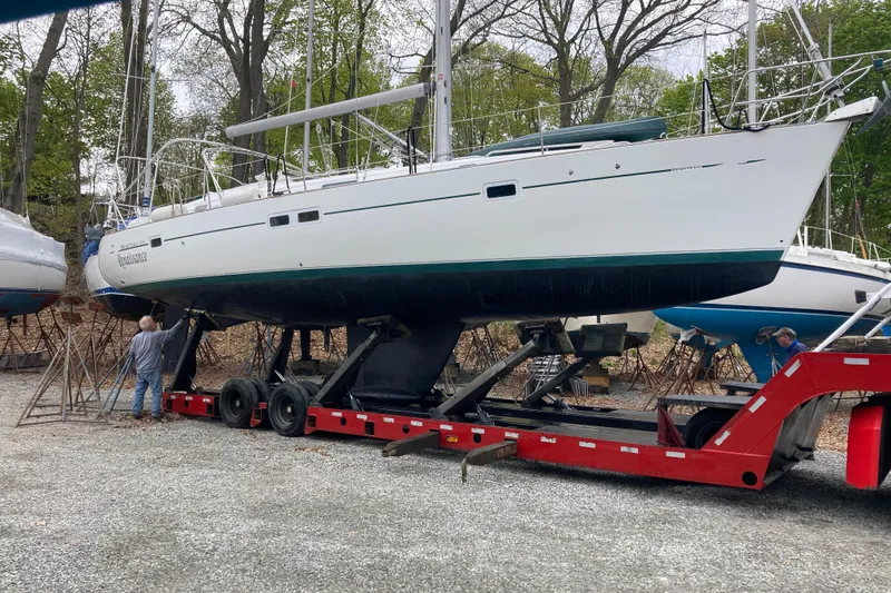 Slide: The Image of 2000 Beneteau Oceanis Clipper 411 sailboat on trailer, surrounded by trees and gravel. - 8
