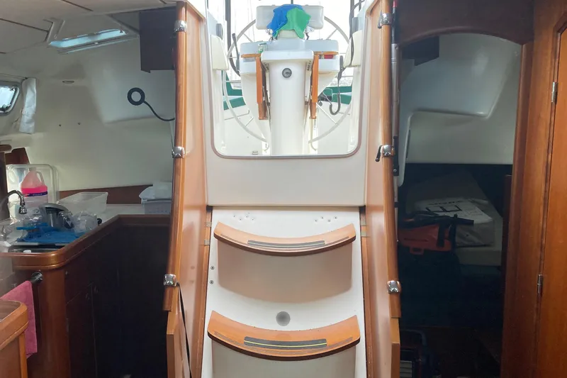 Slide: The Image of Interior view of 2000 Beneteau Oceanis Clipper 411 sailboat, featuring wooden steps and cabin area. - 9