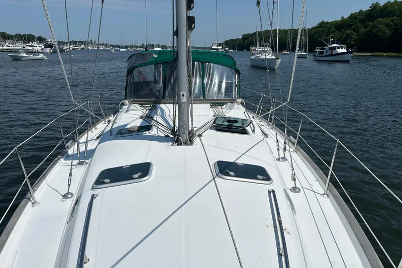 Slide: The Image of Beneteau Oceanis Clipper 411 sailboat on calm water, showcasing deck and rigging. - 10
