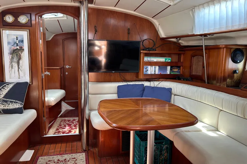 Slide: The Image of Interior of 2000 Beneteau Oceanis Clipper 411 yacht with cozy seating and wooden table. - 13