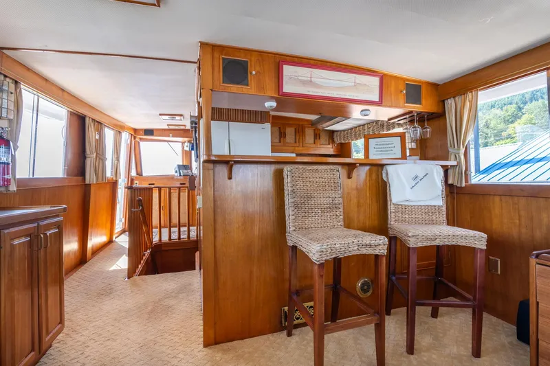 Slide: The Image of Interior of 1976 Grand Banks 52 Europa yacht with wooden furnishings and bar stools. - 10