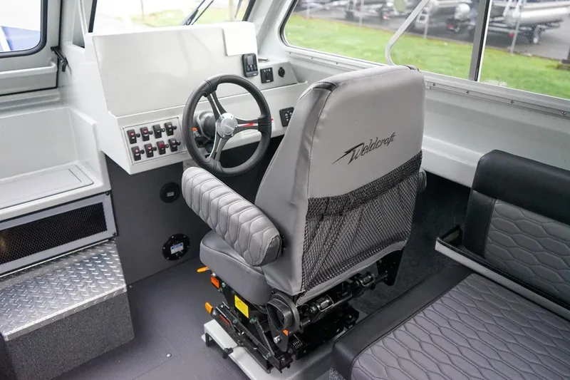 Slide: The Image of Interior of 2026 Weldcraft 260 Ocean King boat with steering wheel and seating. - 13