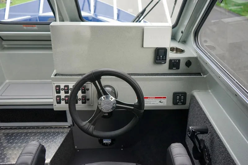 Slide: The Image of Interior helm of 2026 Weldcraft 260 Ocean King boat with steering wheel and control panel. - 14