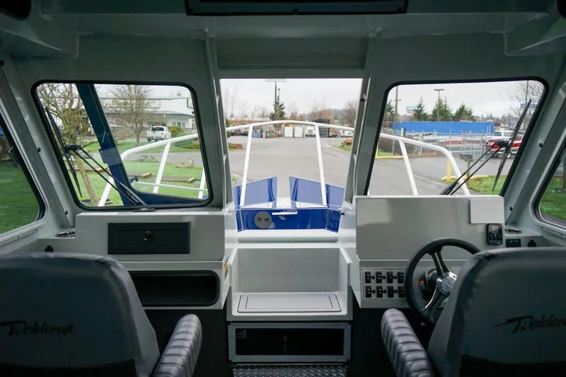 Slide: The Image of Interior view of 2026 Weldcraft 260 Ocean King boat cockpit with steering wheel. - 17