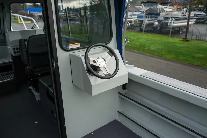 Slide: The Image of Interior view of 2026 Weldcraft 260 Ocean King boat steering wheel and seating area. - 7