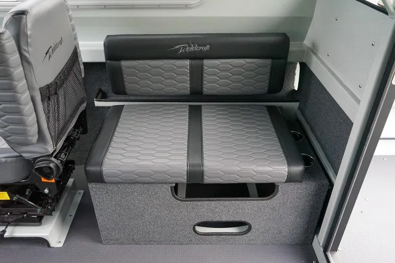Slide: The Image of 2026 Weldcraft 260 Ocean King interior seating with gray upholstery and storage compartment. - 9
