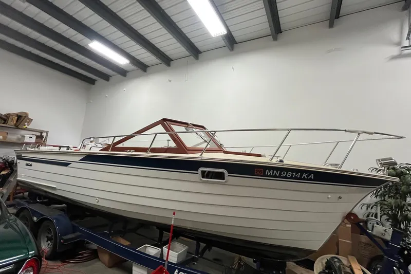 The Image of 2006 Skiff Craft 24' Runabout boat in indoor storage on trailer. - 1