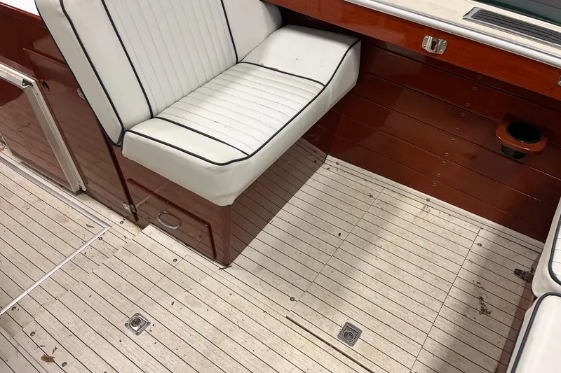 Slide: The Image of Interior of a 2006 Skiff Craft 24' Runabout with white seating and wooden flooring. - 11