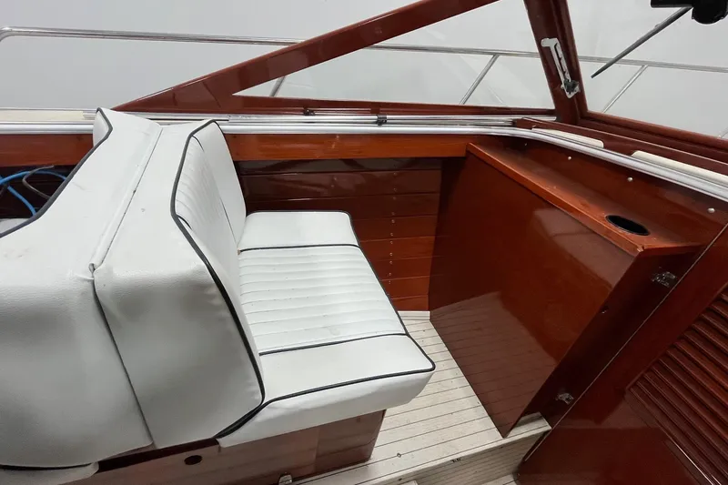 Slide: The Image of 2006 Skiff Craft 24' Runabout interior with white seating and wooden paneling. - 14