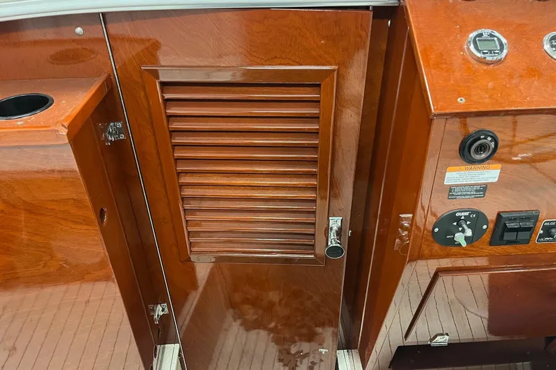 Slide: The Image of 2006 Skiff Craft 24' Runabout interior with wooden cabinetry and control panel. - 15