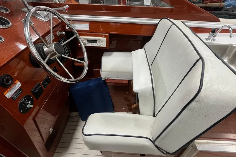 Slide: The Image of 2006 Skiff Craft 24' Runabout interior with white seating and wooden dashboard. - 19