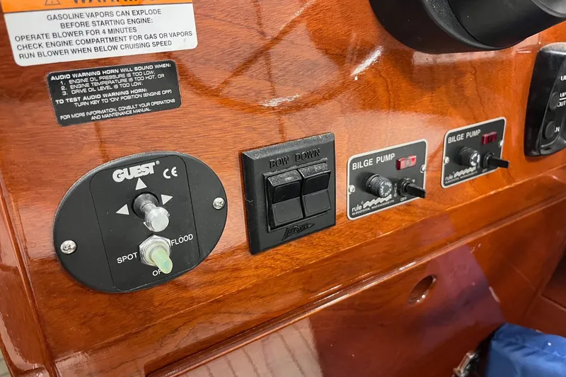Slide: The Image of Control panel of a 2006 Skiff Craft 24' Runabout with switches and warning labels. - 23