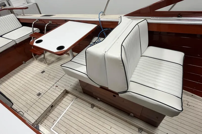 Slide: The Image of Interior of a 2006 Skiff Craft 24' Runabout with white cushioned seating and wooden accents. - 25