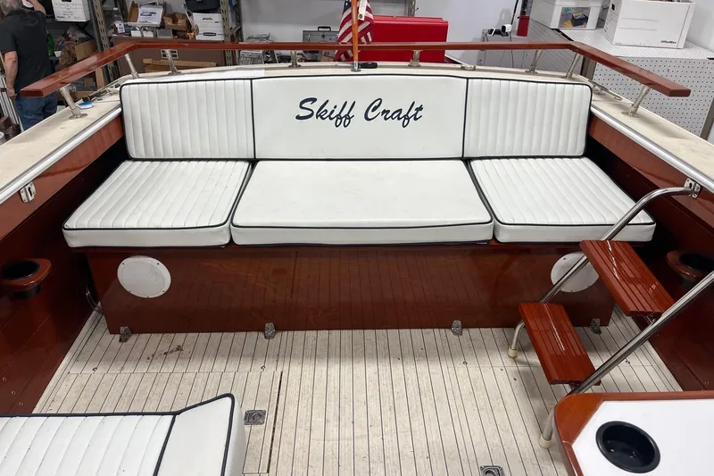 Slide: The Image of 2006 Skiff Craft 24' Runabout interior with white cushioned seating and wooden accents. - 26