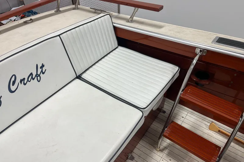 Slide: The Image of 2006 Skiff Craft 24' Runabout with white seating and wooden steps. - 28