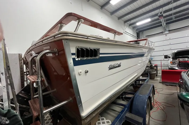 Slide: The Image of 2006 Skiff Craft 24' Runabout boat in a garage, showcasing classic design and craftsmanship. - 6