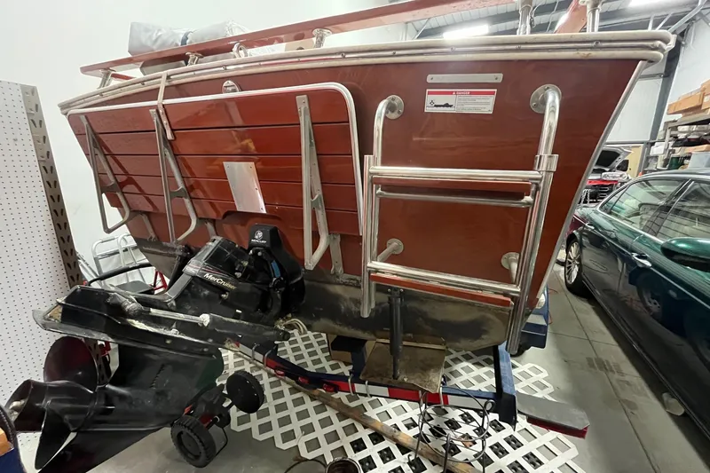 Slide: The Image of 2006 Skiff Craft 24' Runabout boat in storage, showcasing rear view and motor. - 7