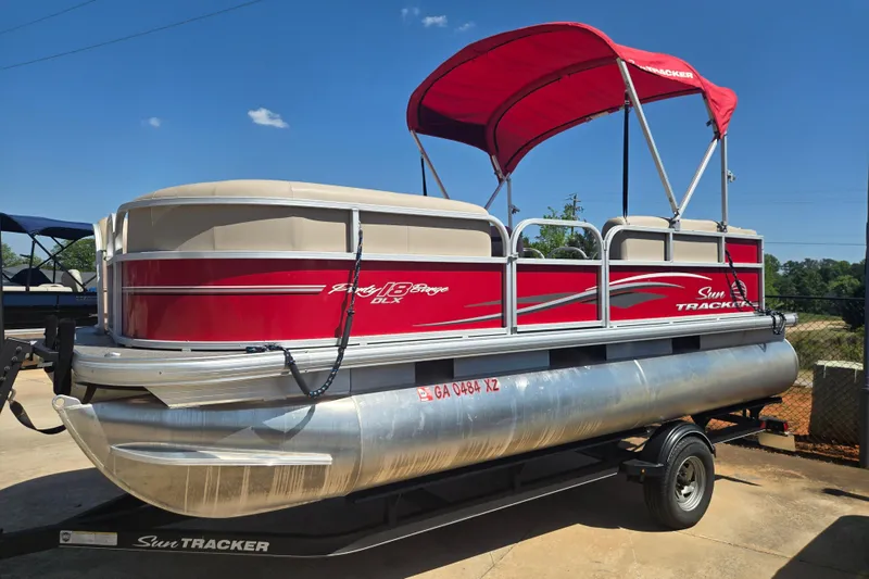 The Image of 2017 Sun Tracker Party Barge 18 DLX pontoon boat with red canopy on trailer. - 1