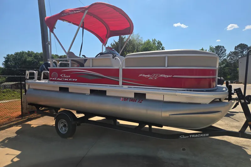 Slide: The Image of 2017 Sun Tracker Party Barge 18 DLX pontoon boat with red canopy on trailer. - 3
