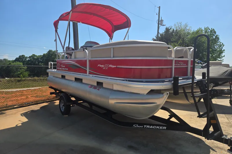 Slide: The Image of 2017 Sun Tracker Party Barge 18 DLX pontoon boat with red canopy on trailer. - 4