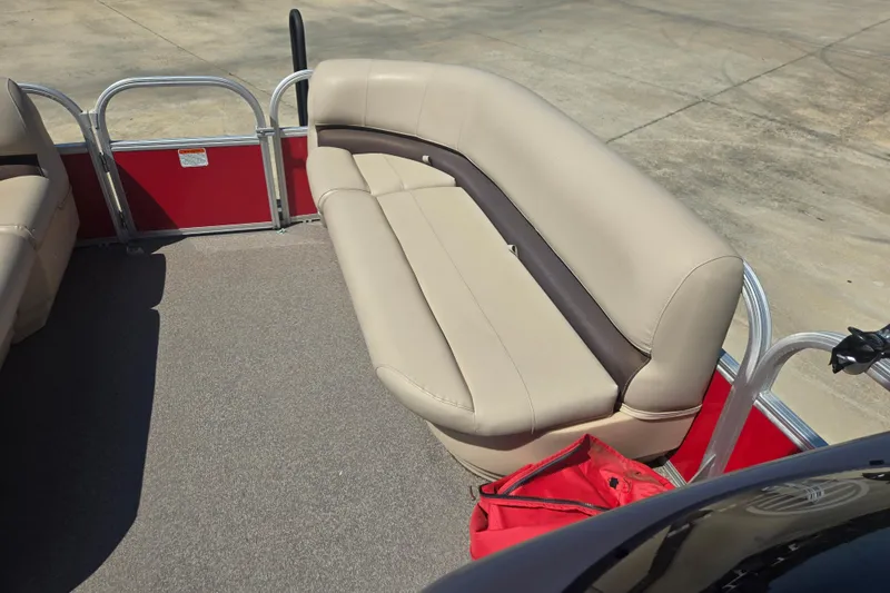 Slide: The Image of 2017 Sun Tracker Party Barge 18 DLX interior with beige seating and red accents. - 8