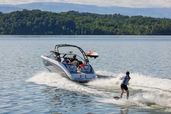 Slide: The Image of 2026 Yamaha Boats AR220 towing a wakeboarder on a scenic lake. - 13