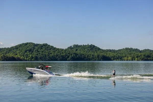 Slide: The Image of Yamaha Boats AR220 2026 towing a wakeboarder on a scenic lake. - 14