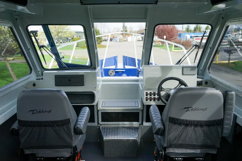 Slide: The Image of Interior view of 2026 Weldcraft 220 Ocean King boat cockpit with dual seats and steering wheel. - 18
