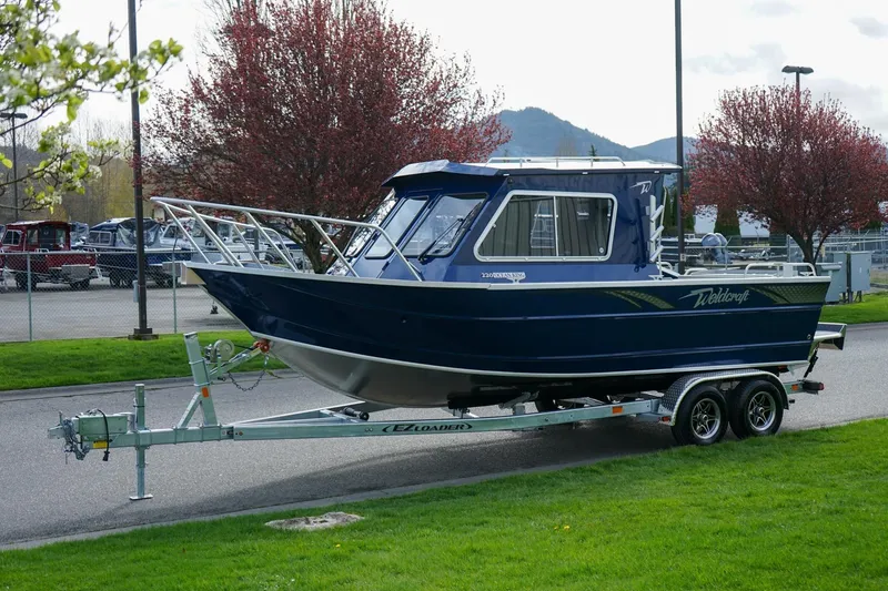 Slide: The Image of 2026 Weldcraft 220 Ocean King boat on trailer, parked outdoors with scenic background. - 21
