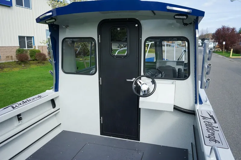 Slide: The Image of 2026 Weldcraft 220 Ocean King boat interior with steering wheel and cabin door. - 5