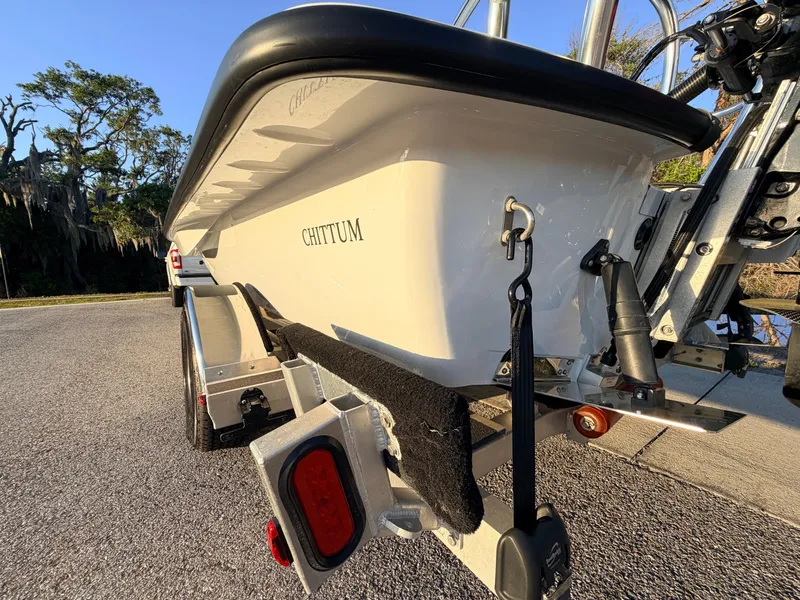 Slide: The Image of 2025 Chittum Skiffs Islamorada 21 boat on trailer, parked on a sunny road. - 16